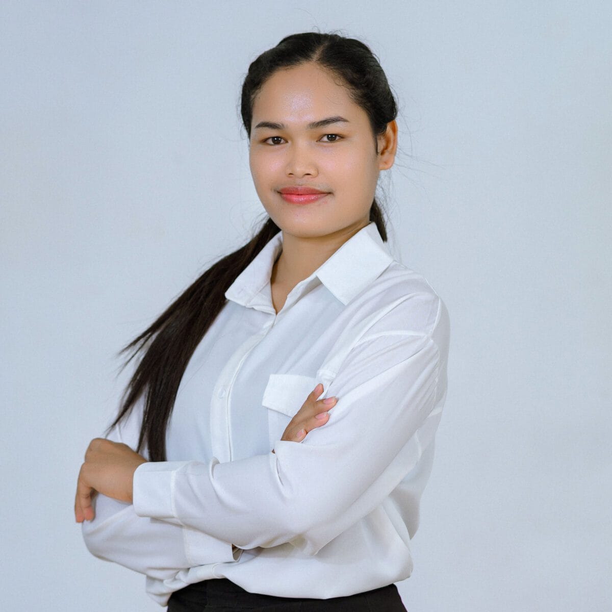 TDSO Confident young woman teacher in white shirt with arms crossed, promoting education and professional.