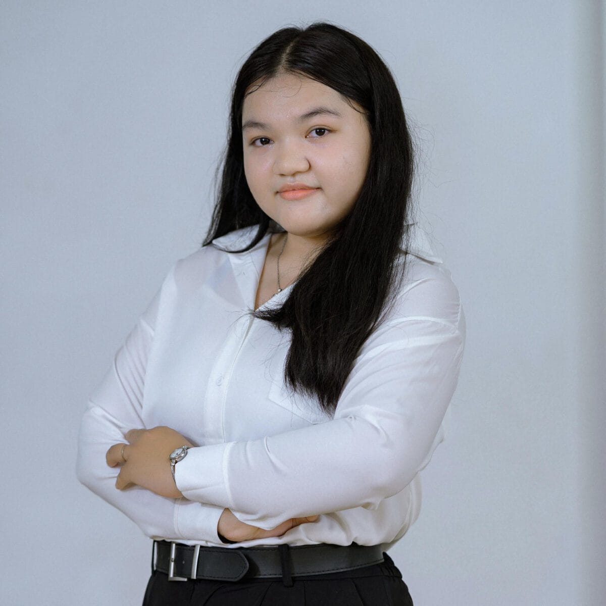 TDSO Confident young woman teacher with crossed arms in professional attire.
