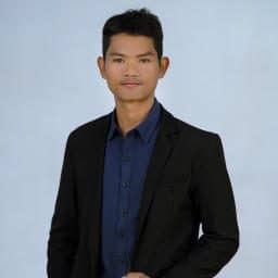 TDSO Young male teacher in formal suit at TDSO event, smiling confidently.