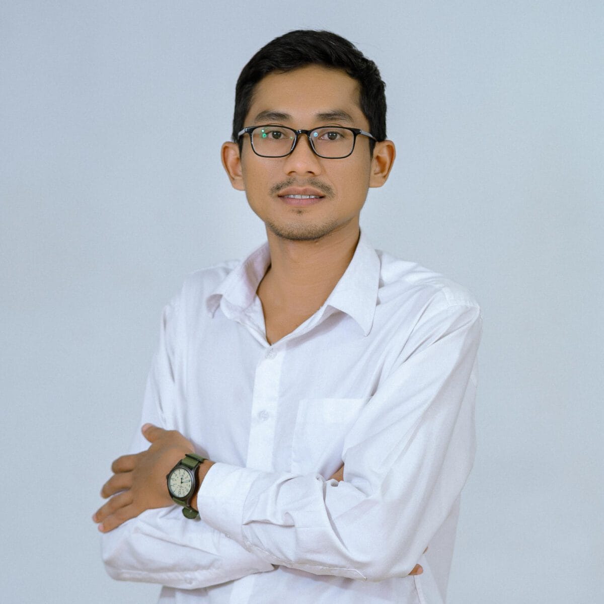 TDSO Confident teacher in white shirt and glasses with crossed arms, promoting professional growth.