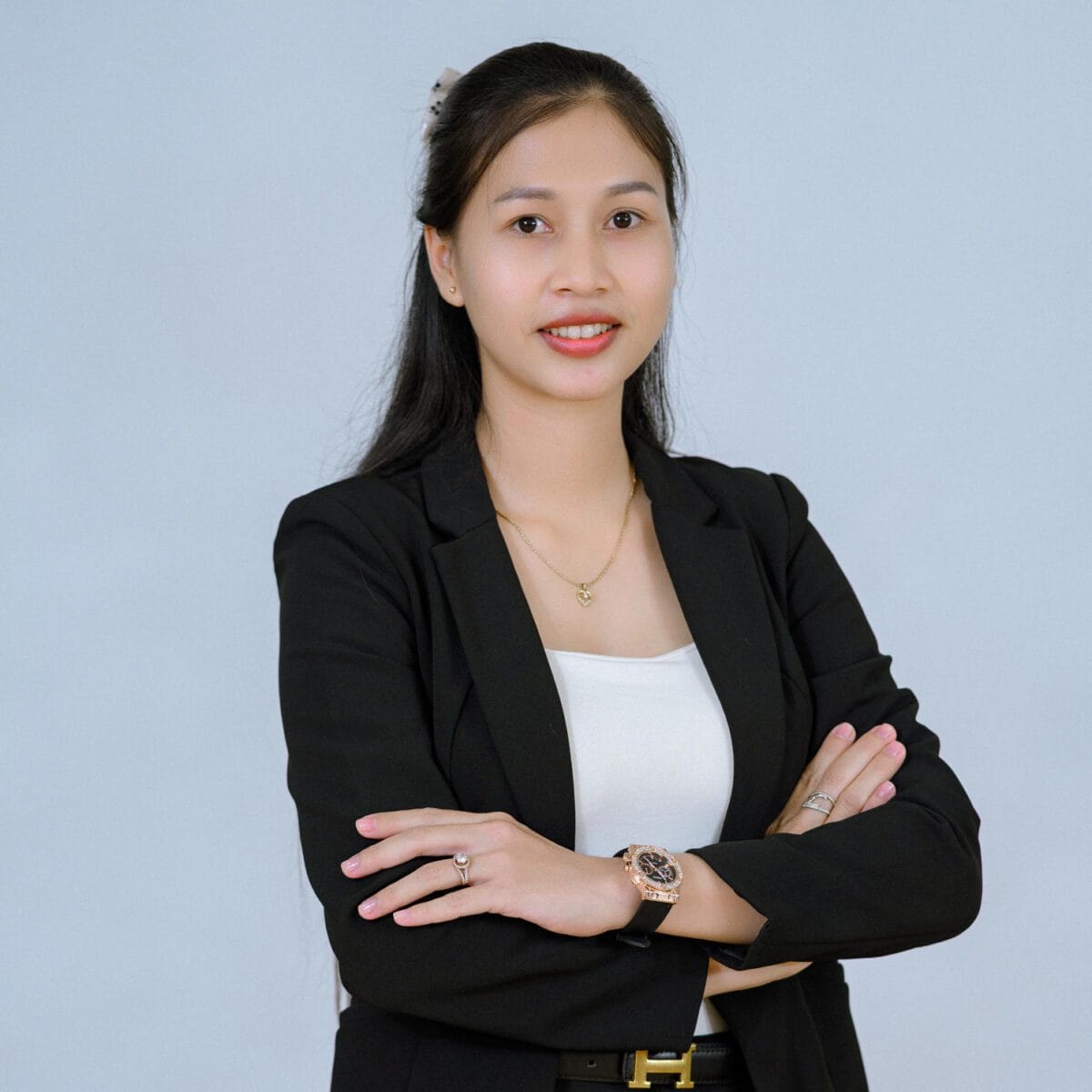 TDSO Professional woman with crossed arms, wearing a black blazer and white top, representing teacher tra.