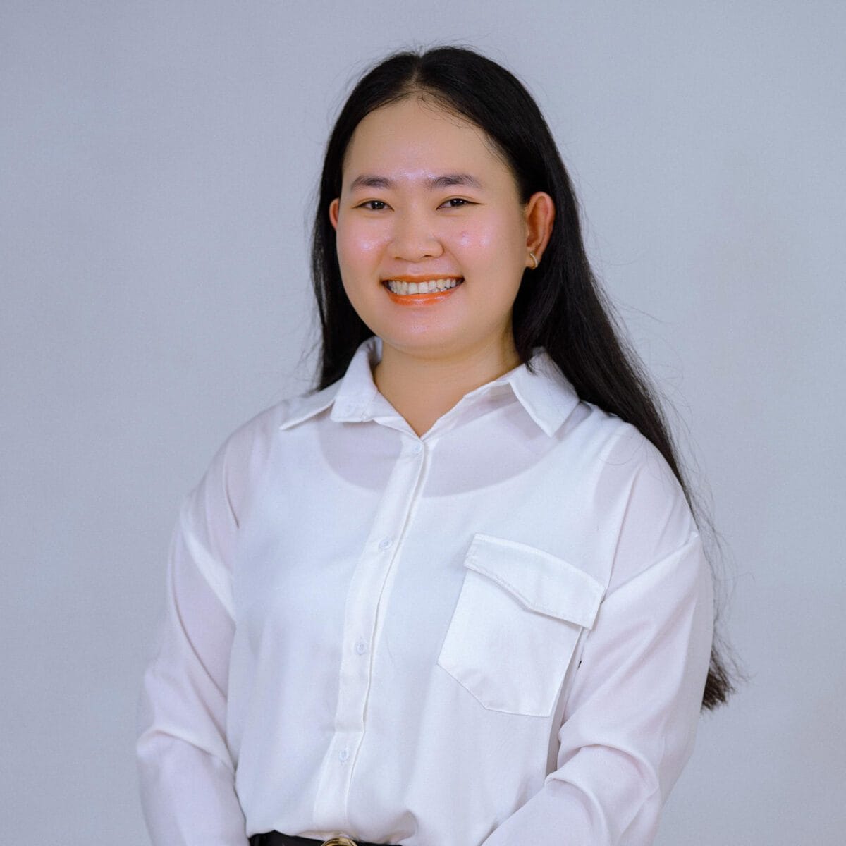 TDSO An Asian woman teacher smiling in a white shirt, representing professional development and support f.