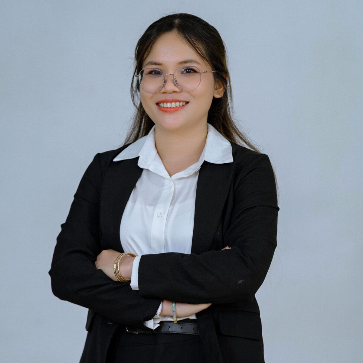 TDSO Professional woman in business attire smiling with arms crossed, representing teacher development an.