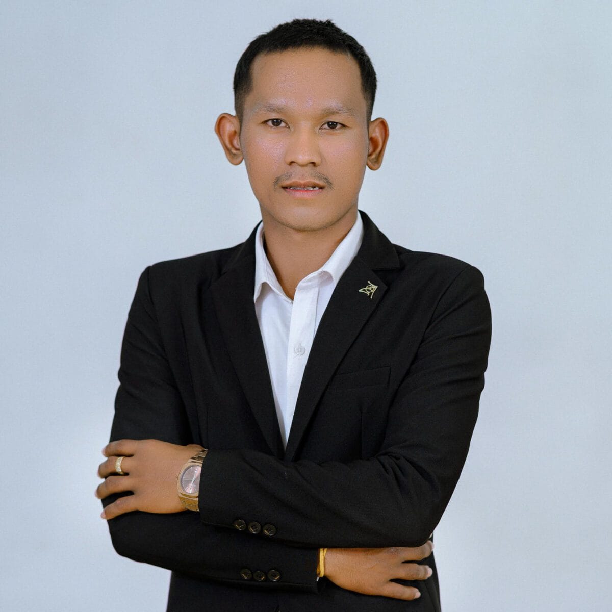 TDSO Professional educator in formal attire with crossed arms, representing teacher development and suppo.