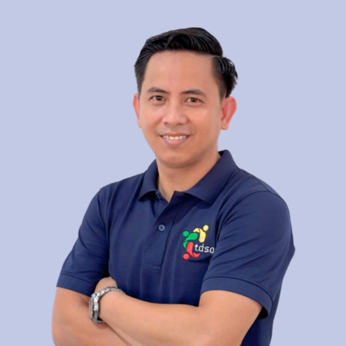 TDSO Professional educator wearing TDSO branded polo shirt with arms crossed, smiling confidently.