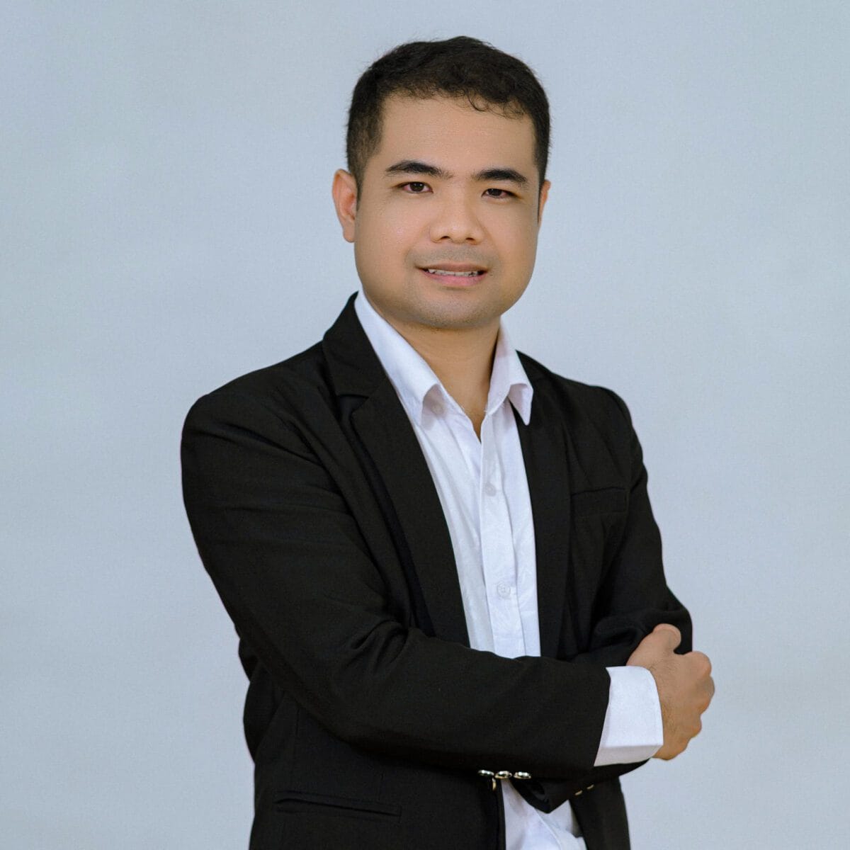 TDSO Professional male educator in formal attire with crossed arms, smiling confidently.