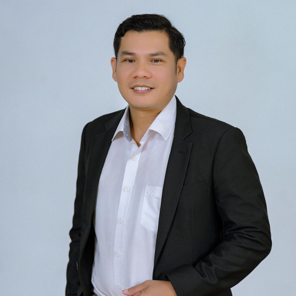 TDSO Professional male educator in formal attire, smiling, against a plain background.