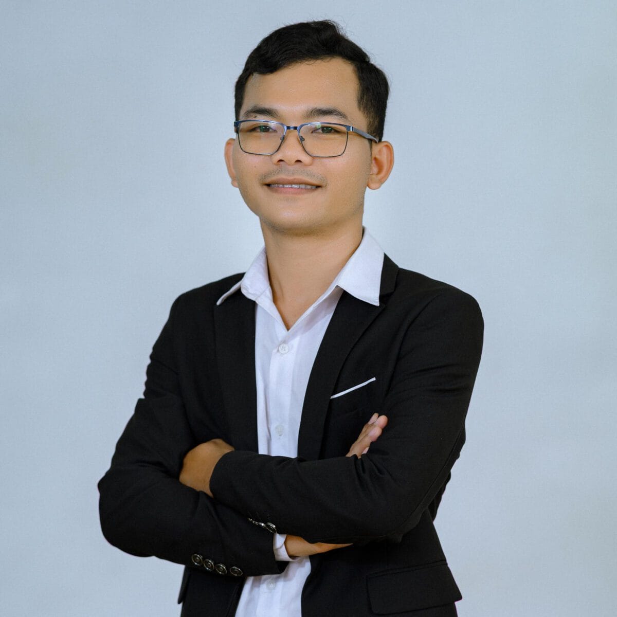 TDSO Educator in formal attire with glasses, smiling confidently, representing teacher development and su.