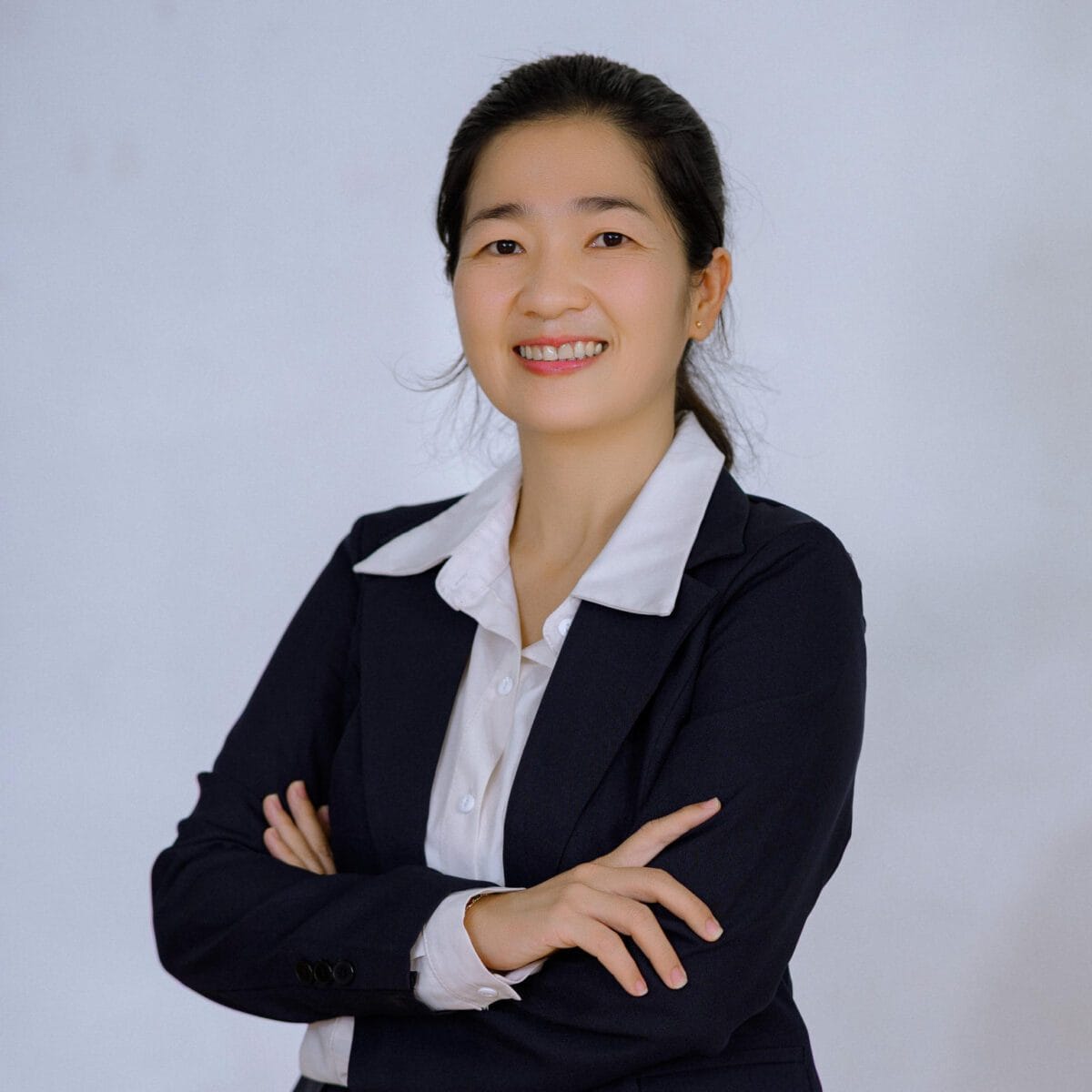 TDSO Confident woman in business suit smiling, representing teacher development and support initiatives.
