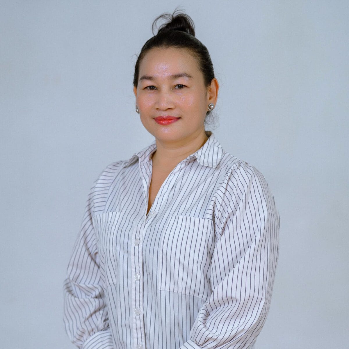 TDSO Female educator in professional attire, smiling confidently, representing teacher development and su.