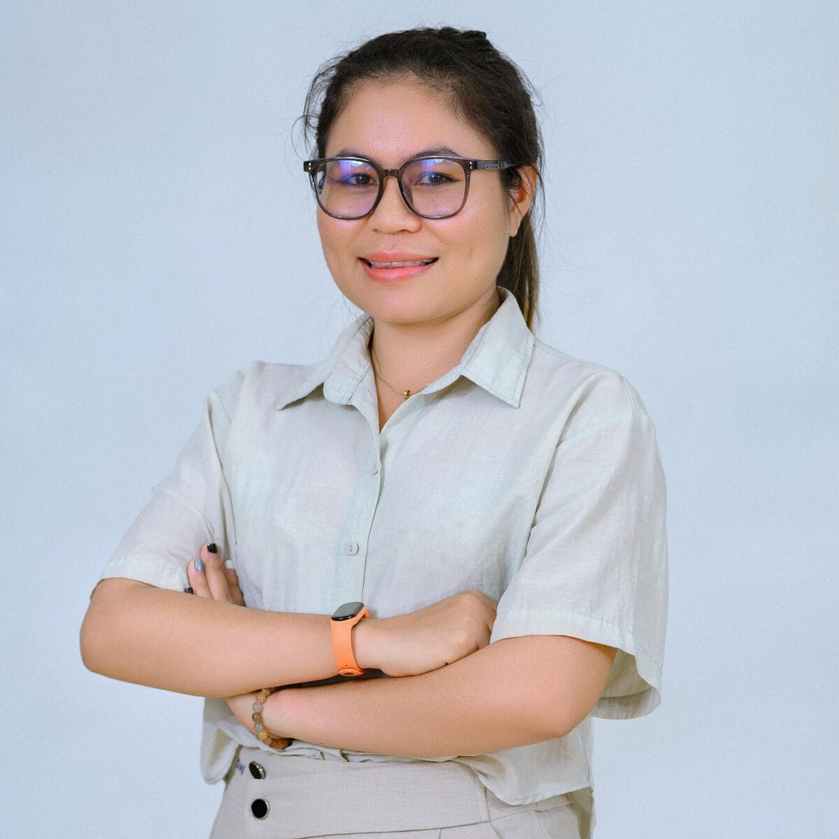 TDSO Educator with glasses and crossed arms, smiling confidently, representing professional development i.