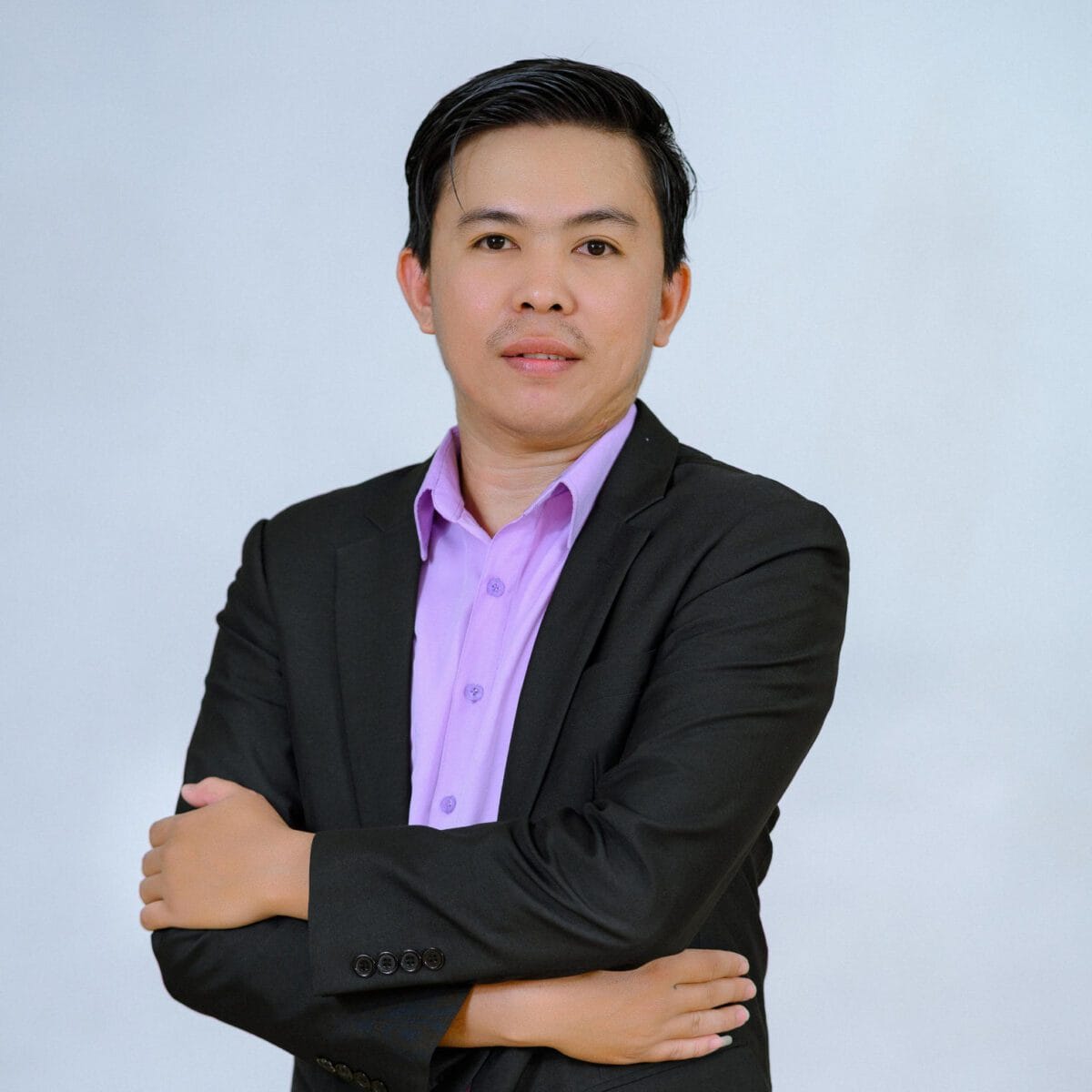 TDSO Educator in formal attire with crossed arms, representing teacher development and support initiative.