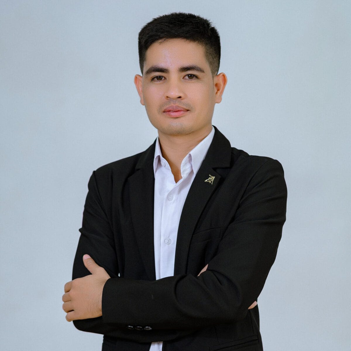 TDSO Professional educator in formal attire with crossed arms, representing teacher development and suppo.