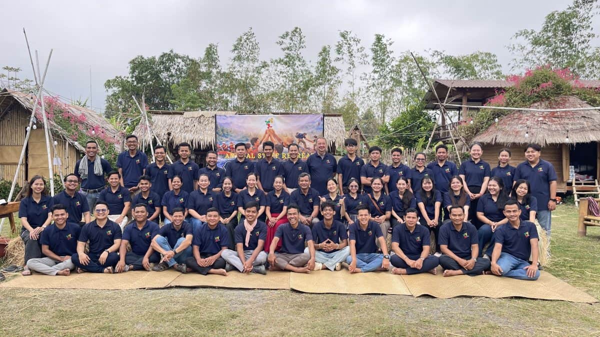 TDSO Group of teachers and staff from TDSO outdoors in a rural setting, smiling and posing for a team pho.